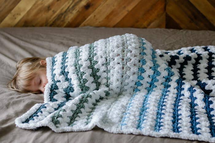 Learn how to make a beginner crochet baby blanket with this easy free pattern and tutorial. You'll be left with very few ends to weave in and a blanket that's as soft as a baby's...well, you know. Get the free pattern featuring Lion Brand Mandala Yarn and Baby Soft Boucle.