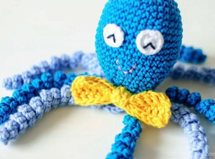 Blue-colored octopus with a yellow bow for a preemie.
